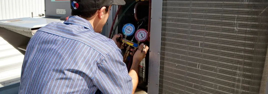HVAC technician servicing a condenser unit in Pine Castle