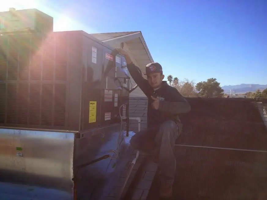 HVAC technician performing Air Duct Cleaning on a rooftop unit in Pine Castle